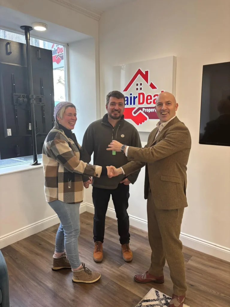 Johnny from Fair Deal shakes hands with a happy client.